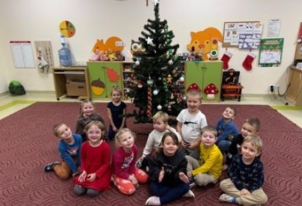 grupa dzieci przedszkolnych podczas ubierania choinki