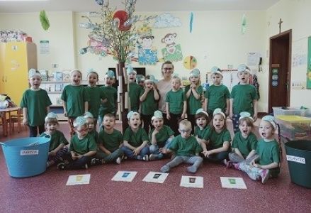 dzieci z wychowawcą ubrani na zielono pozują do grupowego zdjęcia