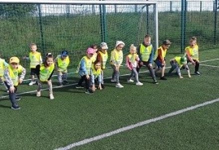 dzieci siedzą na ławce na boisku szkolnym