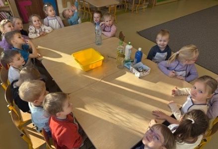 grupa dzieci przedszkolnych podczas zajęć przyrodniczych oraz wykonywania eksperymentów
