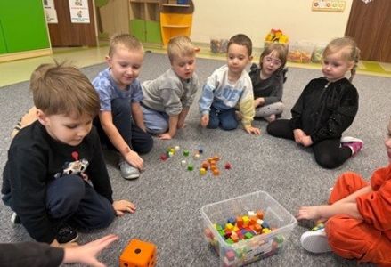 grupa dzieci przedszkolnych podczas zajęć przyrodniczych o dokarmianiu ptaków zimą