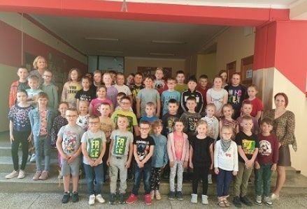 zdjęcie grupowe na szkolnym koryatszu klasy trzeciej i starszaków z przedszkola