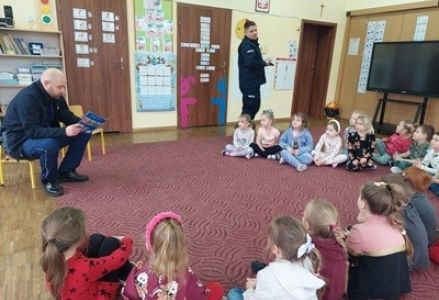 grupa dzieci przedszkolnych podczas spotkania z policjantami dotyczącego bezpieczeństwa dzieci