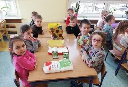 dzieci siedzą przy stolika z produktami do hodowli owsa