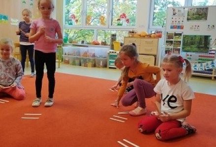 dzieci układają znaki matematyczne z patyczków