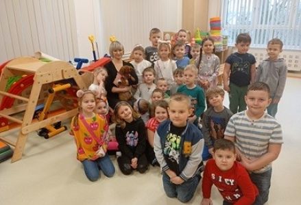 grupa dzieci przedszkolnych podczas spotkania z jamnikiem