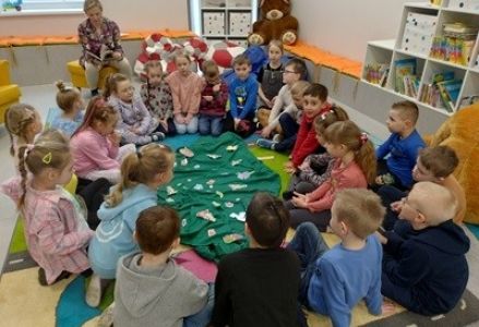 grupa dzieci z wizytą w bibliotece poznaje wiosenne kwiaty