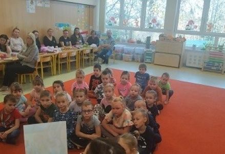 dzieci siedzą w rozsypce na dywanie