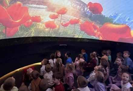 grupa dzieci przedszkolnych podczas seansu kina sferycznego