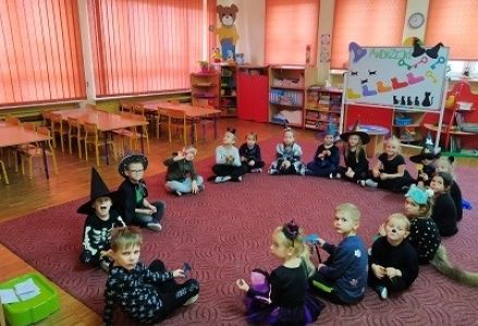 dzieci siedzą w kole
