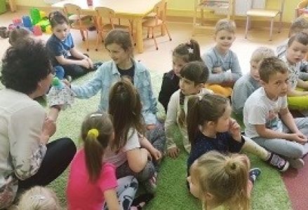 bibliotekarka pokazuje dzieciom motylka