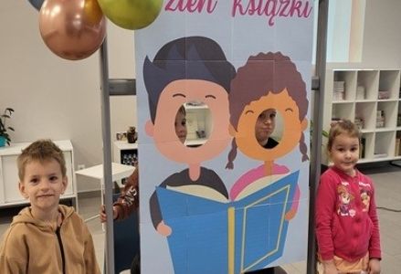 grupa dzieci przedszkolnych podczas obchodów dnia książki w bibliotece