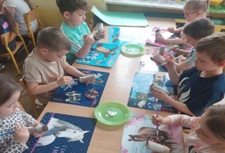 grupa dzieci przedszkolnych podczas wykonywania wielkanocnej pracy plastycznej  - zajączka