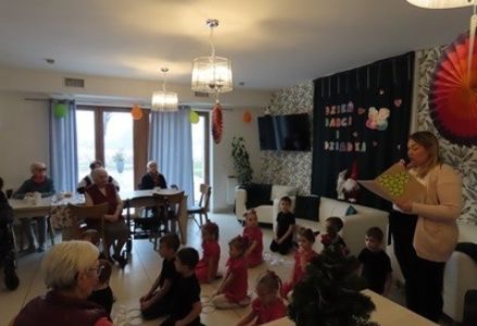 grupa dzieci przedszkolnych podczas wizyty w domu seniora