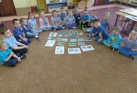 grupa dzieci przedszkolnych podczas wykonywania eksperymentów związanych z wodą