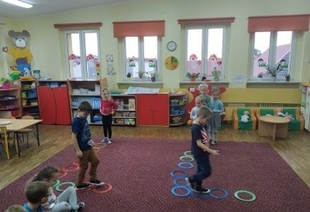 dzieci chodzą po literce "l" ułożonej z obręczy