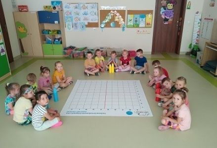 dzieci siedzą wokoło maty