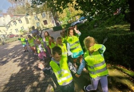 grupa dzieci przedszkolnych uczy się prawidłowo przechodzić przez pasy