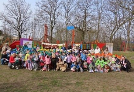 grupa dzieci przedszkolnych podczas poszukiwania wielkanocnego zajączka na placu przedszkolnym