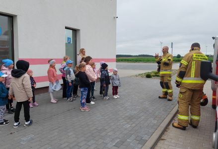grupa dzieci przedszkolnych z wizytą w remizie Ochotniczej Straży Pożarnej z okazji Dnia Strażaka