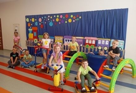 grupa dzieci przedszkolnych podczas zajęć sportowych na mini siłowniowej