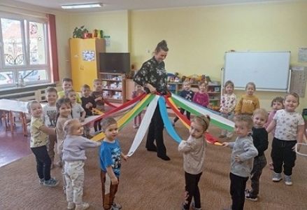 grupa dzieci przedszkolnych podczas zajęć matematycznych z pomocą dydaktyczną - wiatrakiem matematycznym