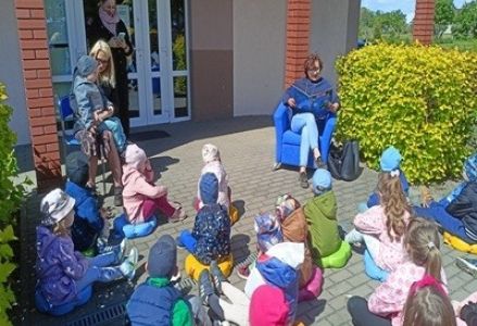 grupa dzieci przedszkolnych podczas głośnego czytania w bibliotece w Radwankach