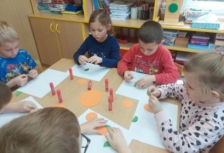 dzieci wykonuja prace plastyczną origami płaskie z kół