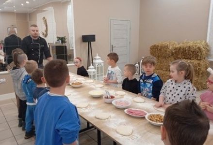 grupa dzieci przedszkolnych podczas warsztatów kulinarnych z okazji Dnia Pizzy