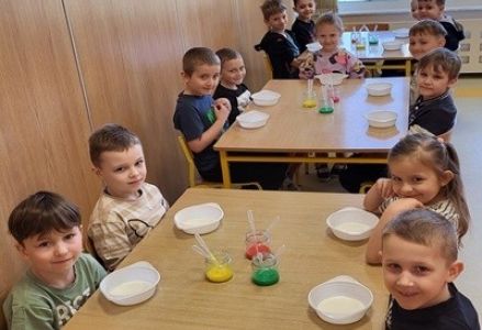 grupa dzieci przedszkolnych podczas eksperymentów przyrodniczych