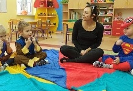 Dzieci siedzą na chuście z wychowawcą