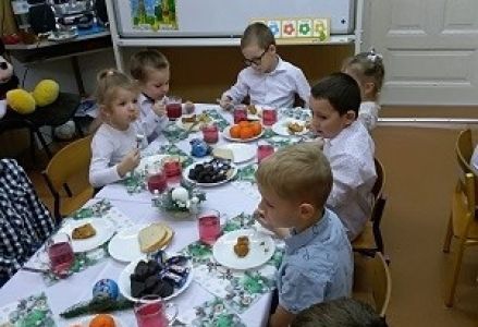 dzieci siedzą przy stole wigilijnym