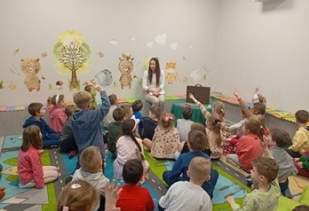 grupa dzieci przedszkolnych podczas teatrzyku kamishibai "Dziewczynka z zapałkami"
