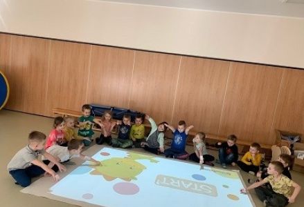 dzieci siedzą przed magicznym dywanem
