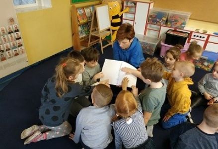 dzieci oglądają książkę dla niewidomych