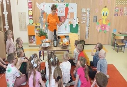 grupa dzieci podczas zajęć o zdrowym odżywaniu z pielęgniarką