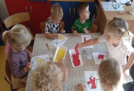 grupa dzieci przedszkolnych podczas wykonywania pracy plastycznej o owocach