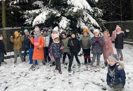 dzieci bawią sie na zaśniezonym placu zabaw
