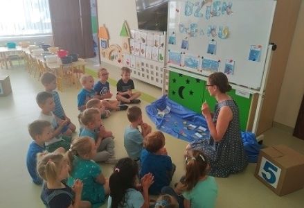 dzieci siedzą przy tablicy