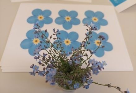 grupa dzieci przedszkolnych podczas zajęć w bibliotece z okazji dnia niezapominajki