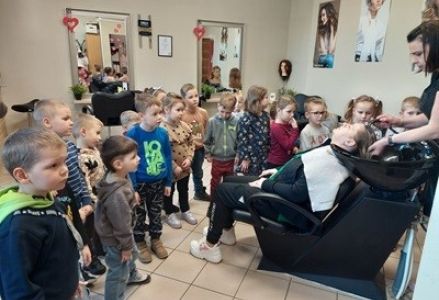 grupa dzieci z przedszkola z wizyta w salonie fryzjerskim