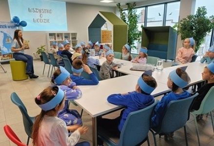grupa dzieci przedszkolnych podczas zajęć bibliotecznych dotyczących oszczędzania wody