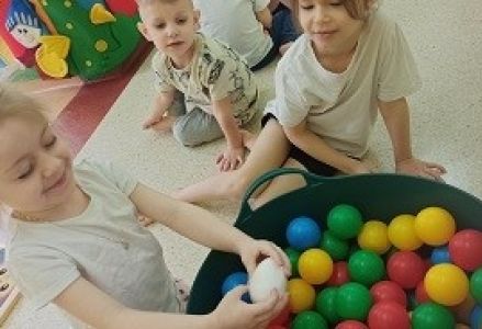 dzieci bawią się kolorowymi piłeczkami