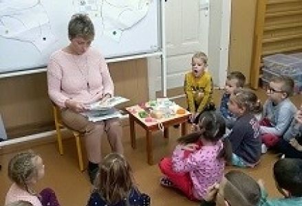 pielęgrniarka pokazuje dzieciom ilustracje tematyczne
