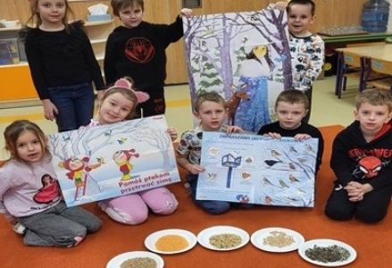 grupa dzieci przedszkolnych podczas zajęć przyrodniczych o dokarmianiu ptaków zimą