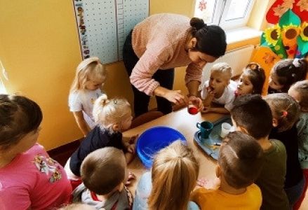 dzieci wraz z nauczycielką przygotowują ciastolinę