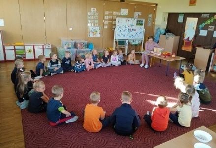 dzieci siedzą przez panią pielęgniarką
