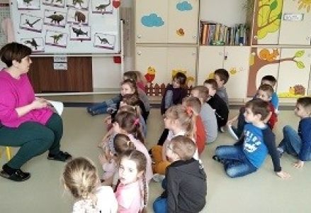 grupa dzieci siedzi w kole
