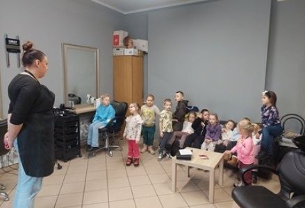 grupa dzieci przedszkolnych podczas wizyty w salonie fryzjerskim