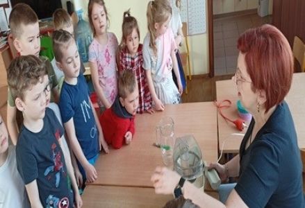 grupa dzieci podczas zajęć kulinarnych wykonują sok owocowy